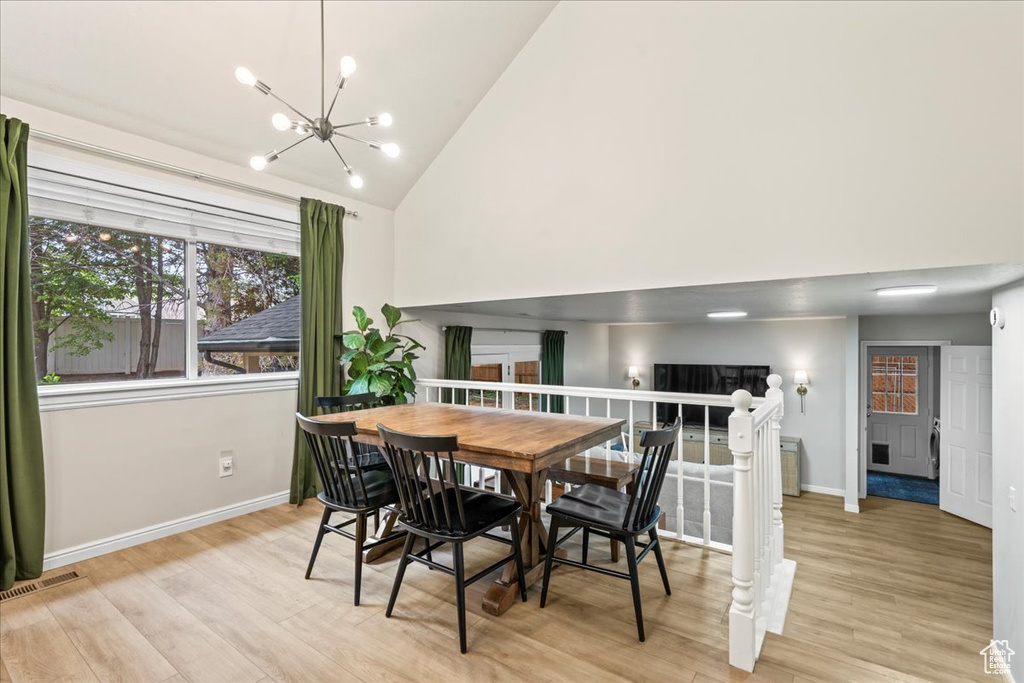Dining room featuring baseboards, light wood-style floors, a chandelier, and visible vents