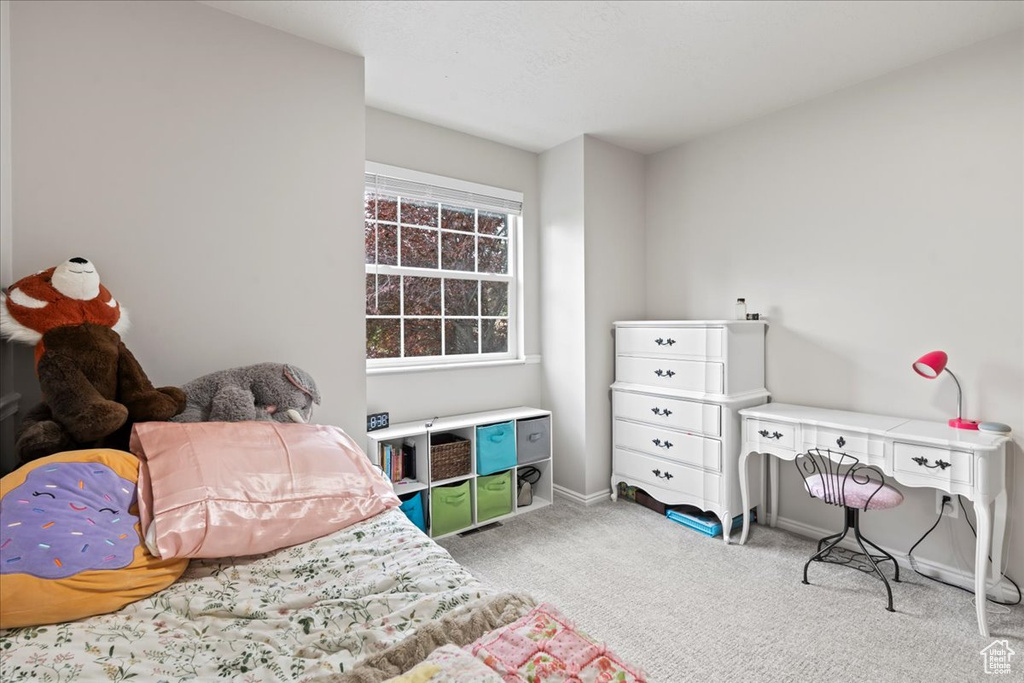 Bedroom with light colored carpet and baseboards