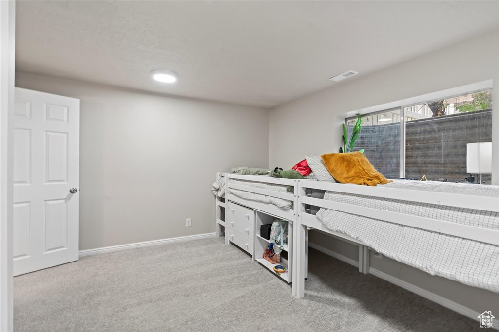 Carpeted bedroom featuring baseboards and visible vents