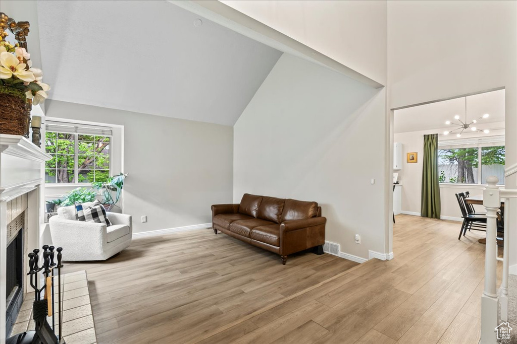 Living room with plenty of natural light, a fireplace, visible vents, and light wood-style flooring