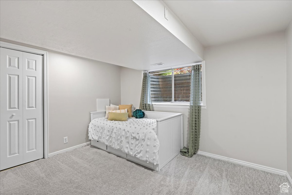 Carpeted bedroom with a closet and baseboards