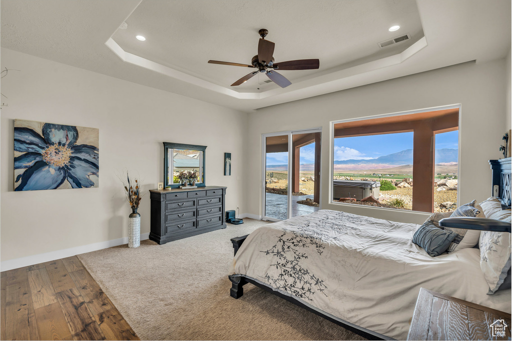 Bedroom featuring visible vents, access to exterior, baseboards, recessed lighting, and a tray ceiling