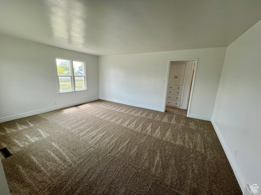 Carpeted spare room with baseboards and visible vents