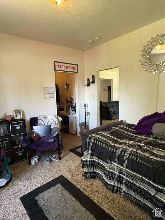 Bedroom with a textured ceiling and carpet flooring