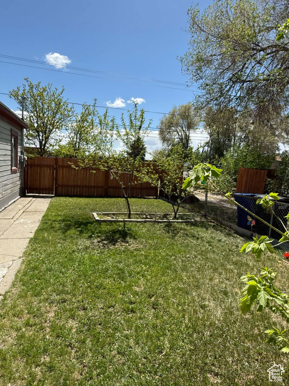 View of yard featuring a fenced backyard and a gate