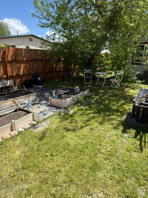 View of yard with a vegetable garden and fence