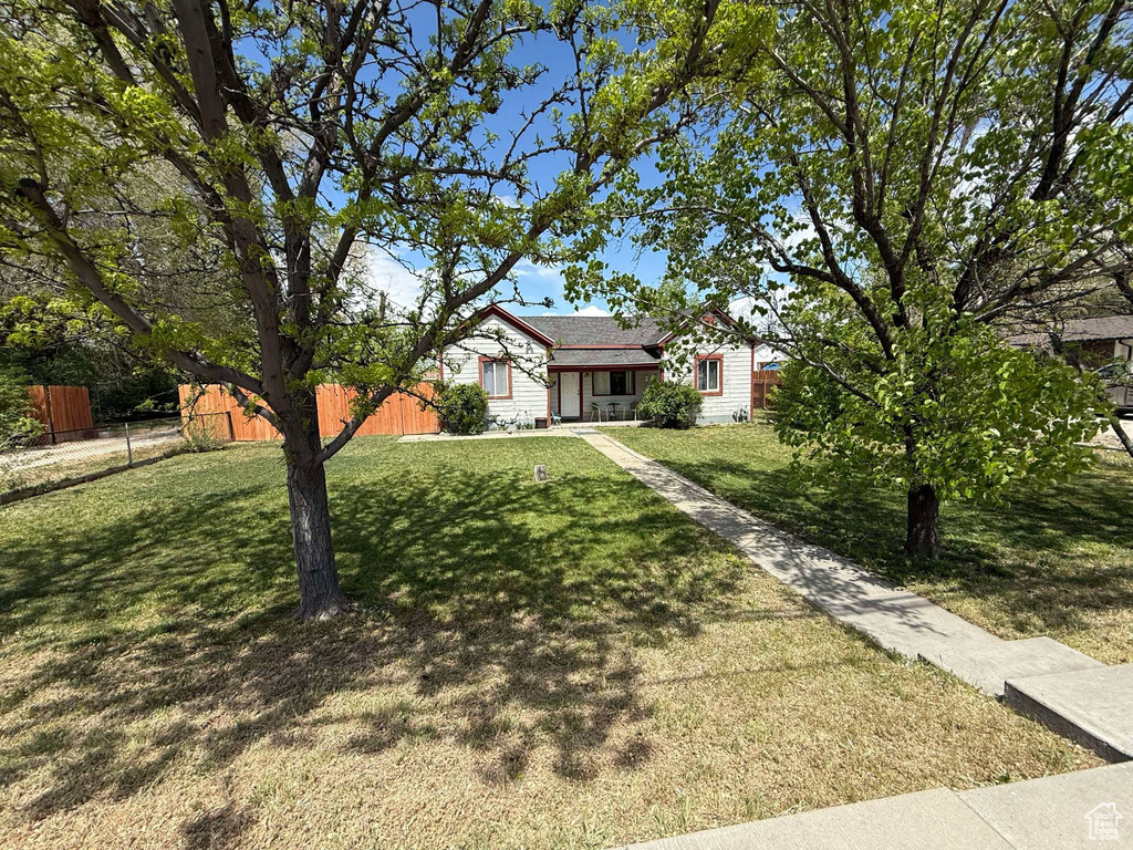 View of front of home with fence and a front yard