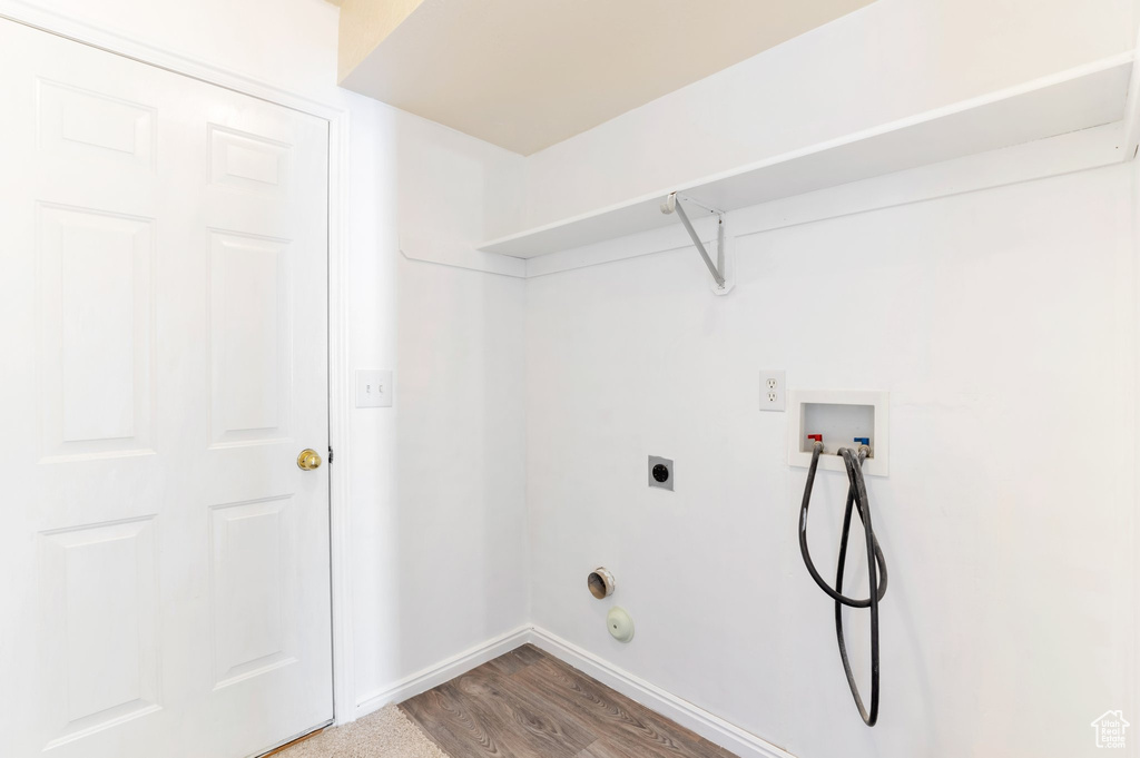 Laundry room featuring baseboards, hookup for a washing machine, wood finished floors, laundry area, and electric dryer hookup