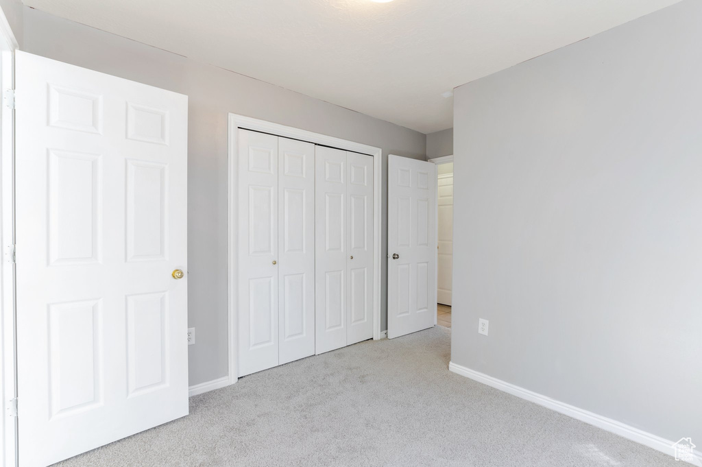 Unfurnished bedroom featuring baseboards, a closet, and carpet floors
