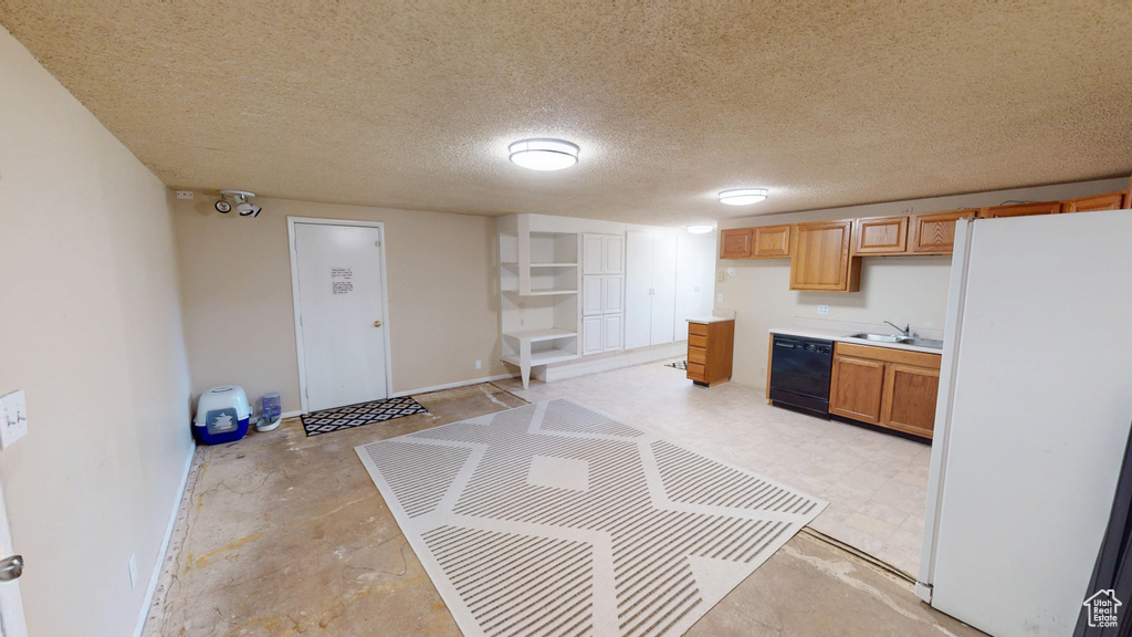 Kitchen with freestanding refrigerator, dishwasher, and light countertops