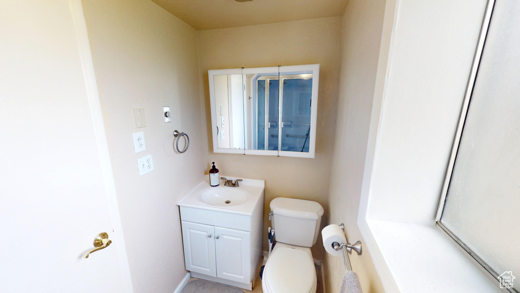 Half bathroom featuring vanity and toilet