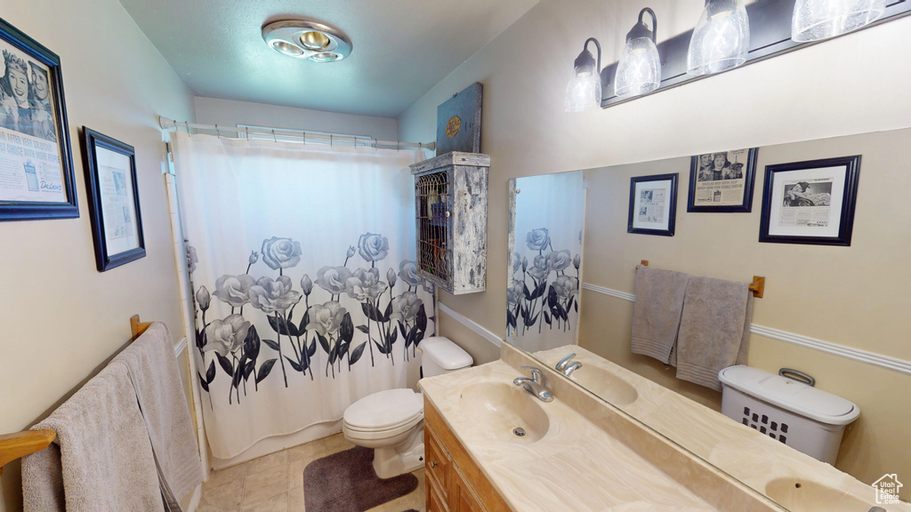 Full bath featuring tile patterned floors, toilet, a shower with shower curtain, and vanity