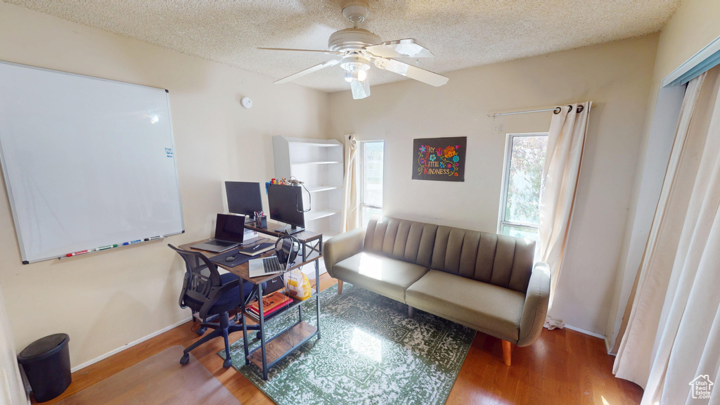Living room with baseboards, ceiling fan, and wood finished floors