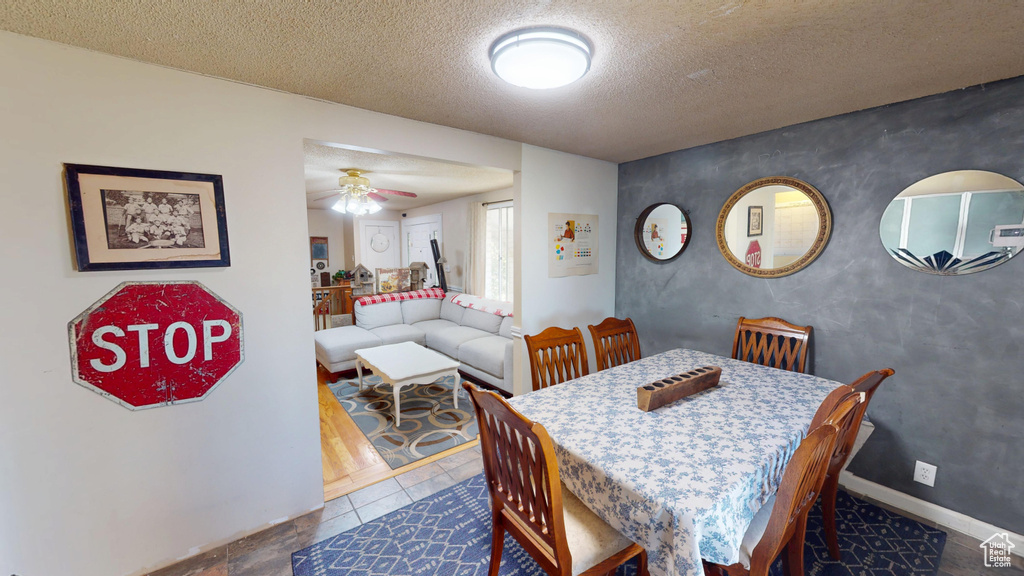 Dining area with ceiling fan and a textured ceiling