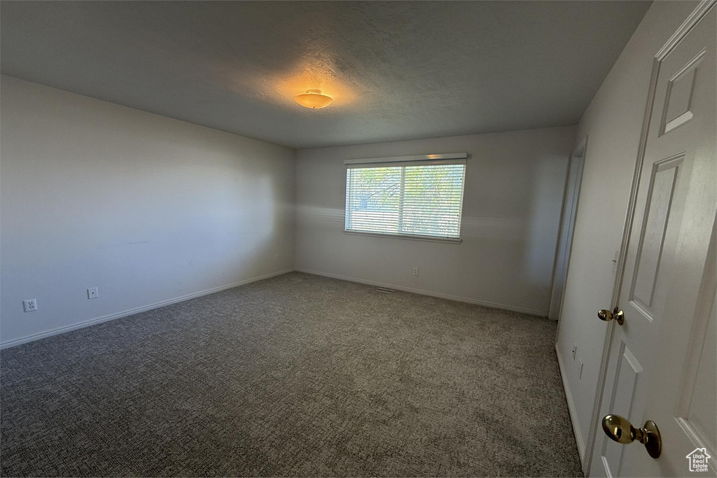 Spare room featuring baseboards and carpet floors