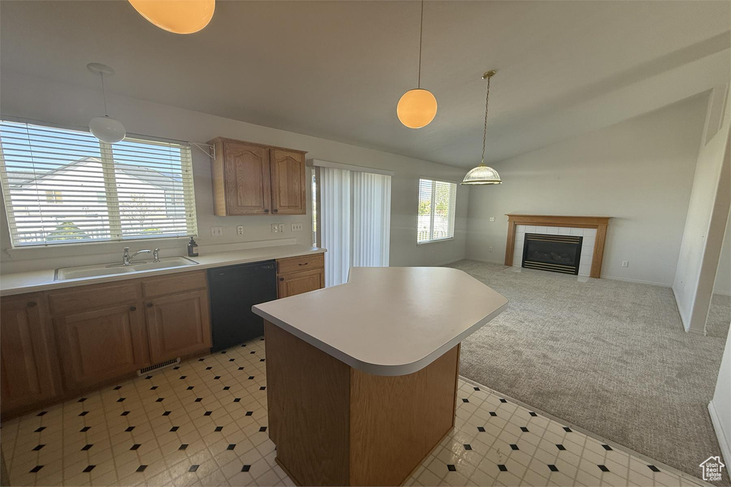 Kitchen featuring a sink, lofted ceiling, black dishwasher, light countertops, and a center island