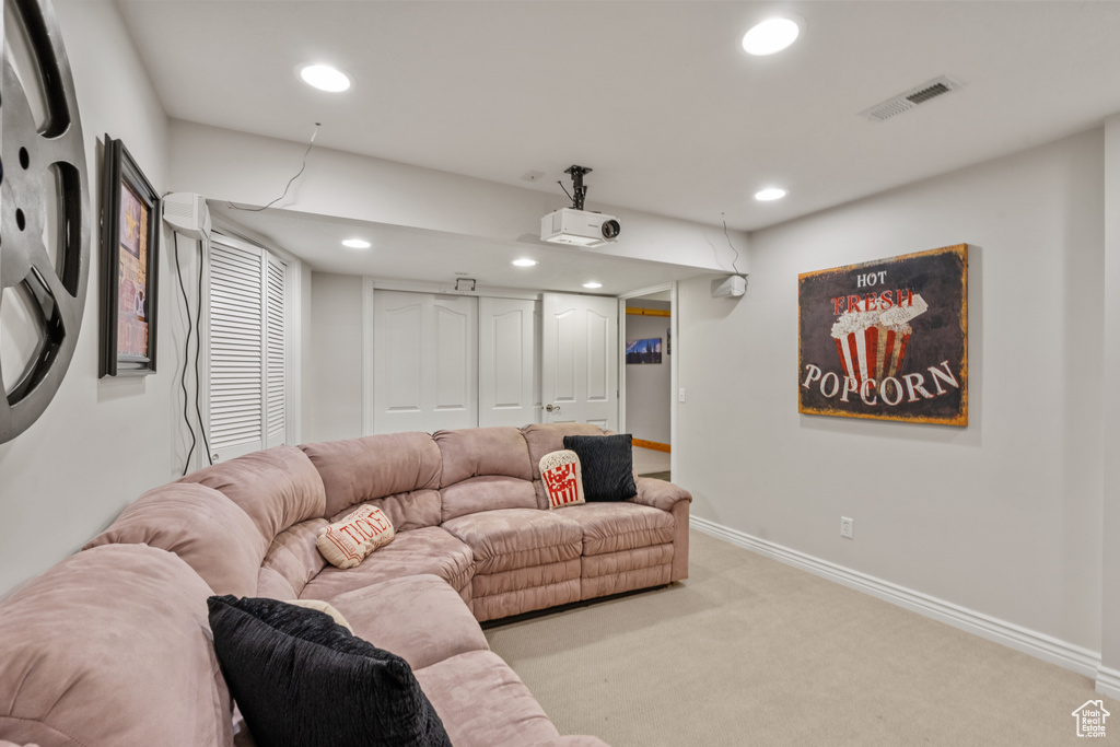 Carpeted living area featuring recessed lighting, baseboards, and visible vents