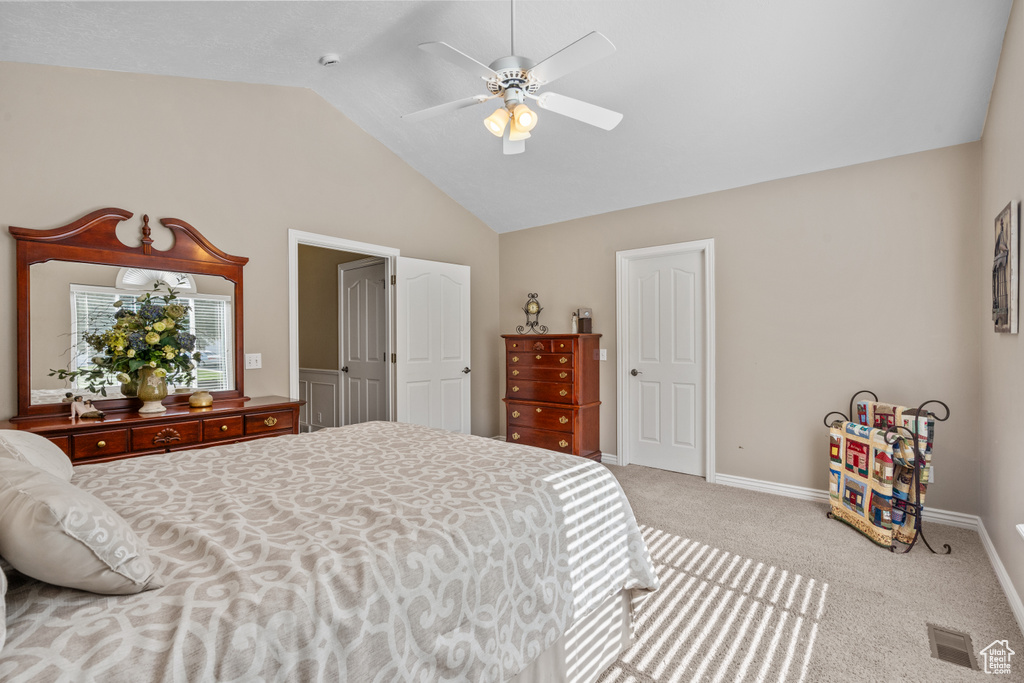 Carpeted bedroom with baseboards, a ceiling fan, lofted ceiling, and visible vents