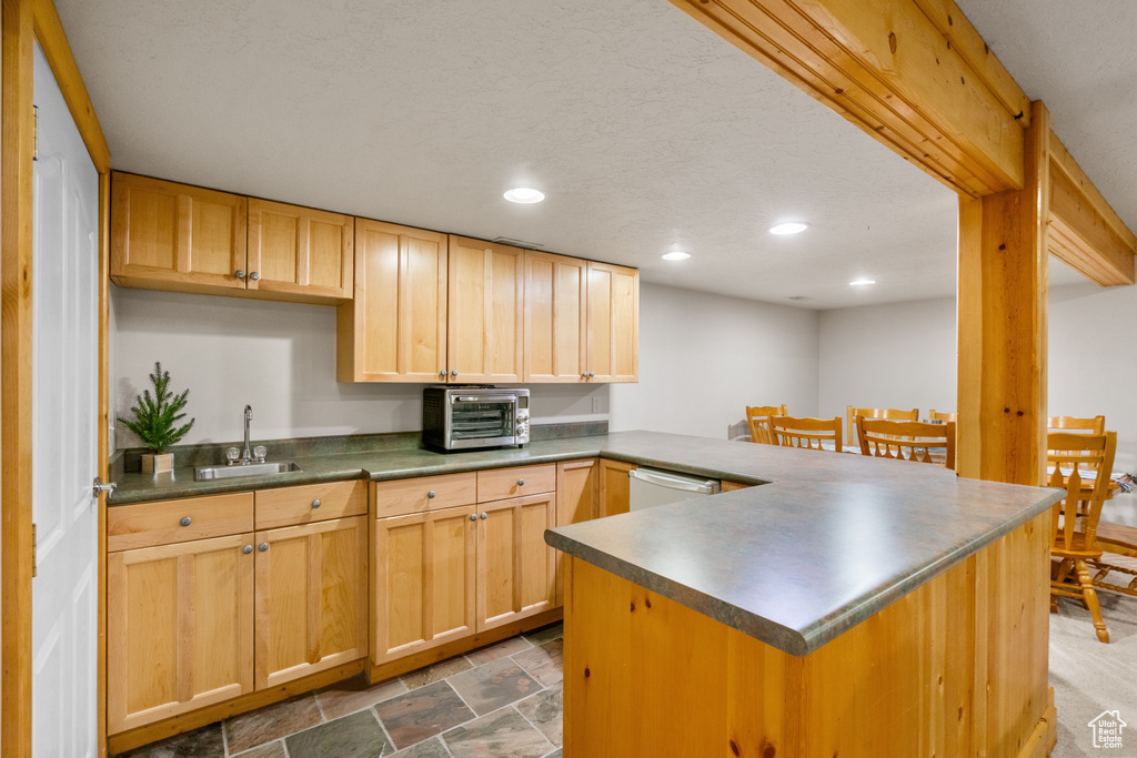 Kitchen featuring dark countertops, a sink, a toaster, a peninsula, and recessed lighting