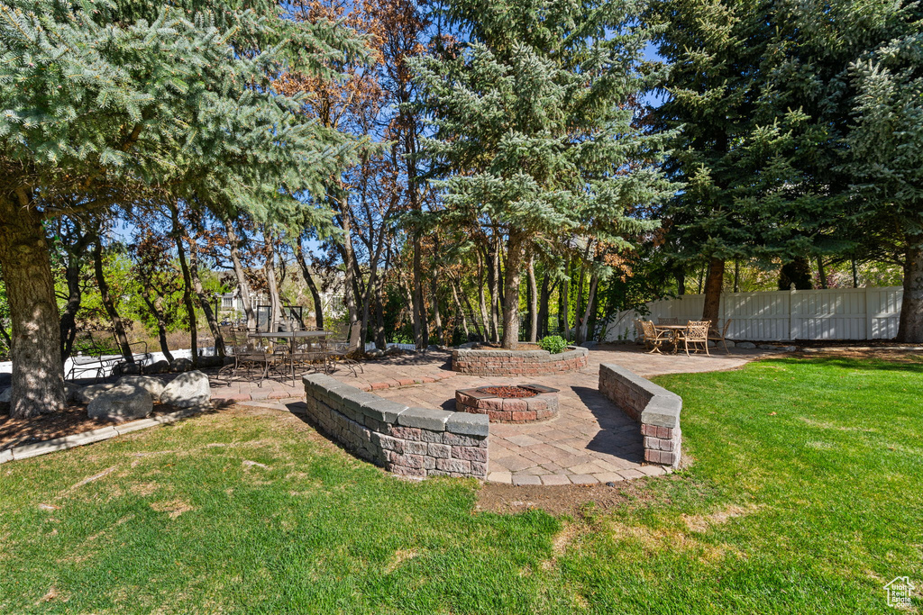 View of yard with a patio, a fire pit, and fence