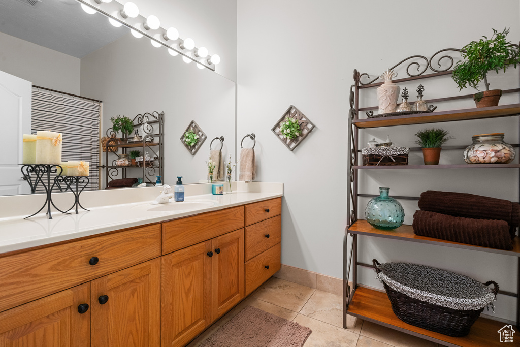 Bathroom featuring tile patterned floors, baseboards, and vanity