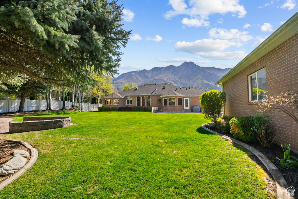 View of yard featuring fence and a mountain view