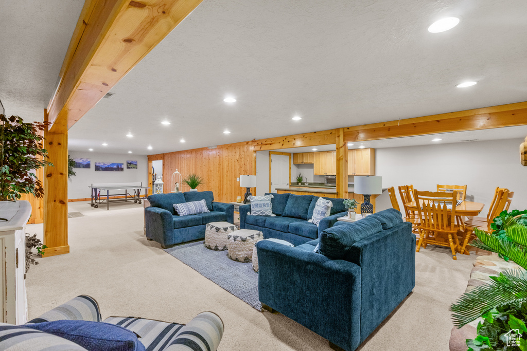 Living room with recessed lighting, wood walls, baseboards, and light colored carpet