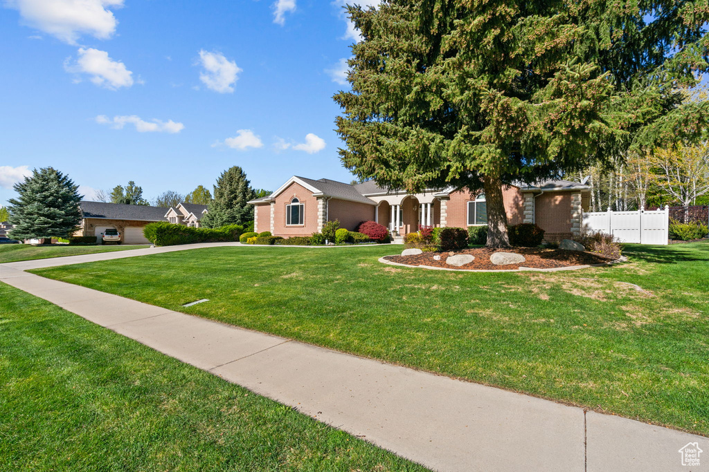 Ranch-style house with fence, brick siding, and a front yard