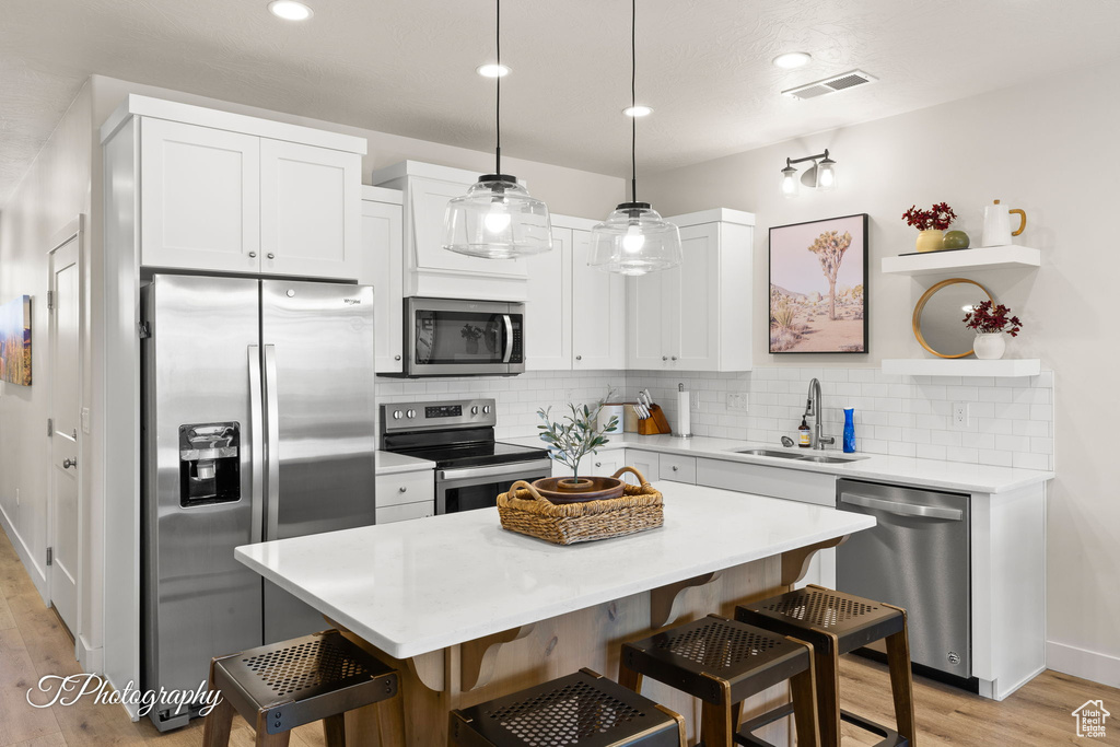 Kitchen with visible vents, a breakfast bar area, appliances with stainless steel finishes, and a sink