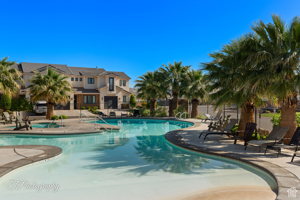 Community pool featuring fence and a patio