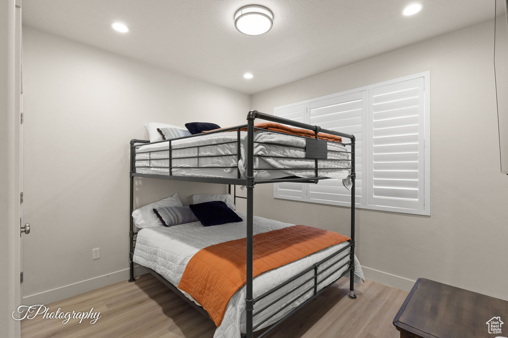 Bedroom with light wood-style flooring, baseboards, and recessed lighting