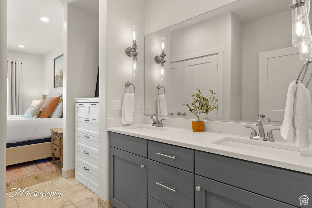 Ensuite bathroom featuring recessed lighting, ensuite bathroom, double vanity, and a sink