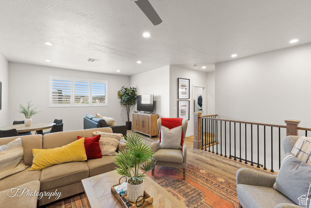Living area featuring visible vents, wood finished floors, ceiling fan, and recessed lighting