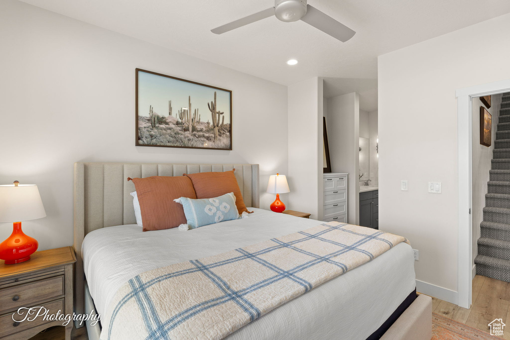 Bedroom featuring ensuite bath, recessed lighting, light wood-style flooring, a walk in closet, and baseboards