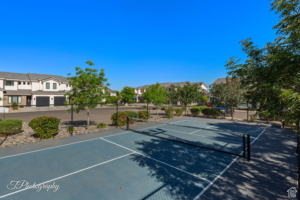 View of tennis court featuring fence and a residential view