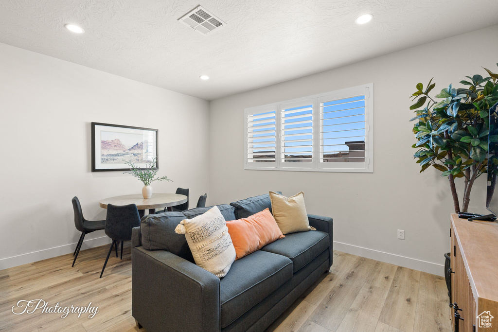 Living area featuring baseboards, recessed lighting, light wood-style flooring, and visible vents
