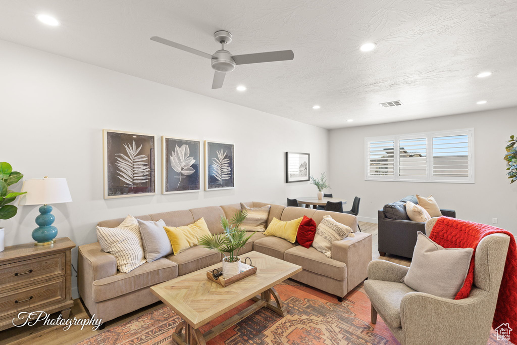 Living room with a ceiling fan, recessed lighting, visible vents, and wood finished floors
