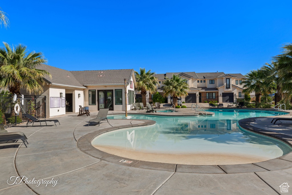 Pool featuring fence and a patio area