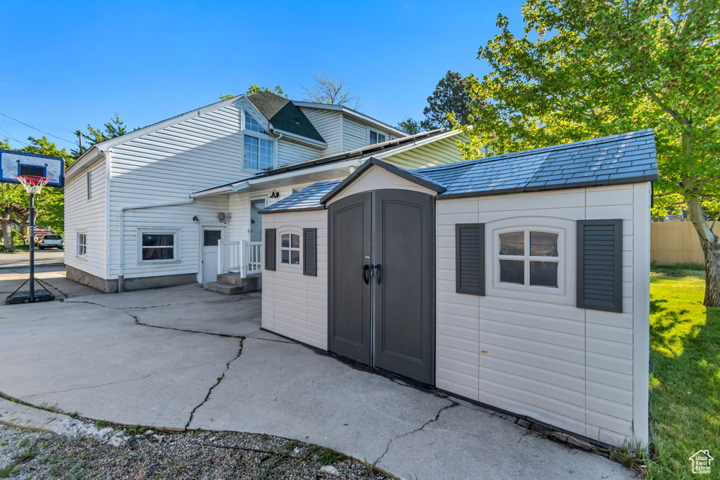 Exterior space with a patio area, a storage shed, and an outdoor structure