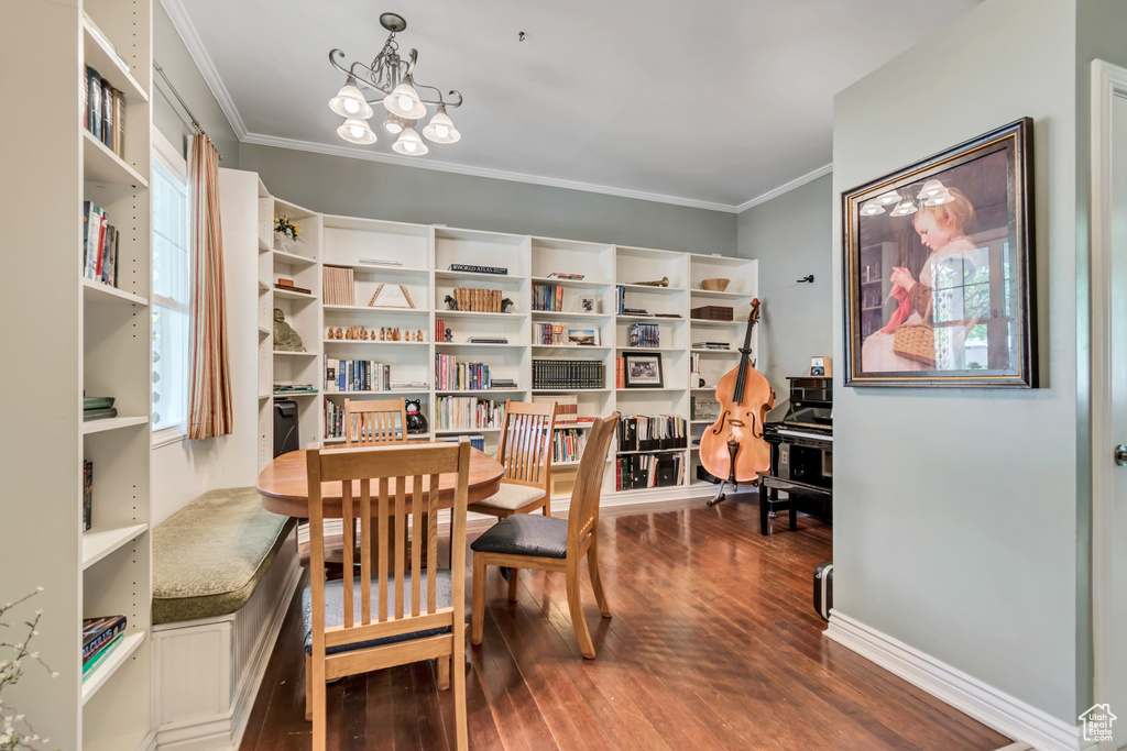 Sitting room featuring baseboards, a notable chandelier, ornamental molding, and dark wood-style floors