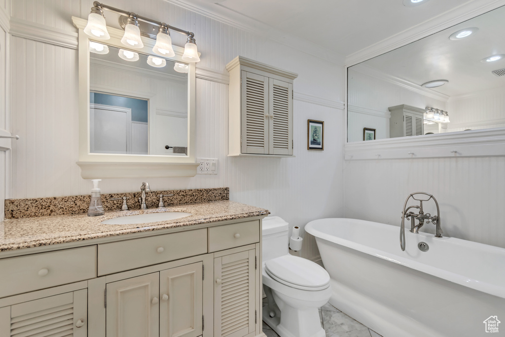 Bathroom featuring a freestanding bath, toilet, marble finish floor, and ornamental molding