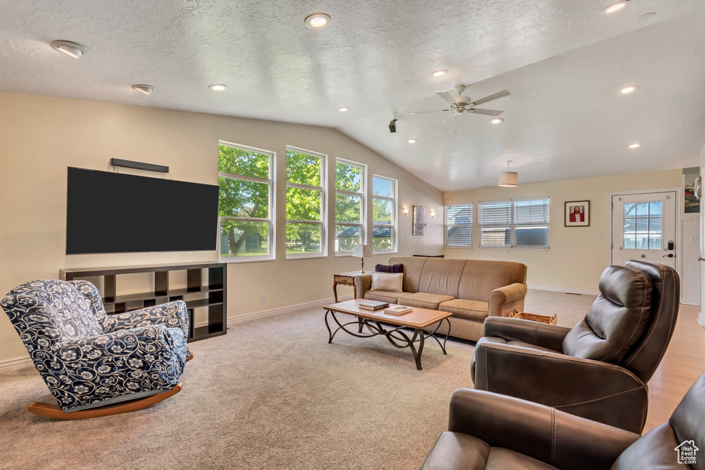 Living area featuring recessed lighting, vaulted ceiling, ceiling fan, carpet flooring, and baseboards