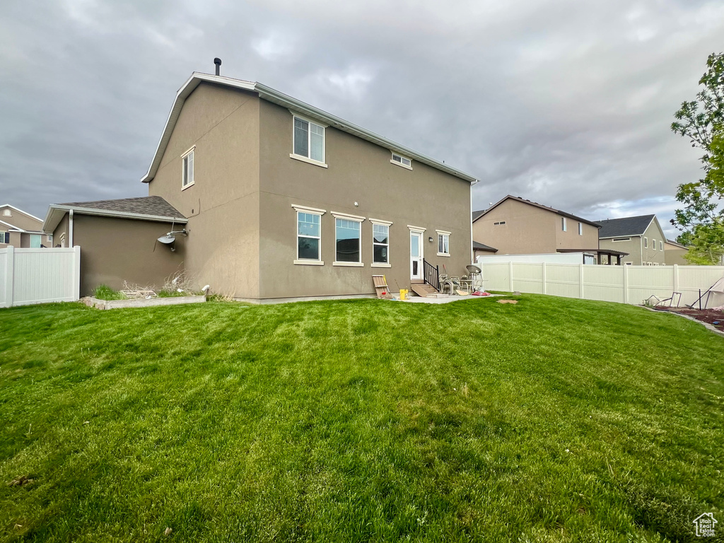 Back of house with a yard, a patio area, and a fenced backyard