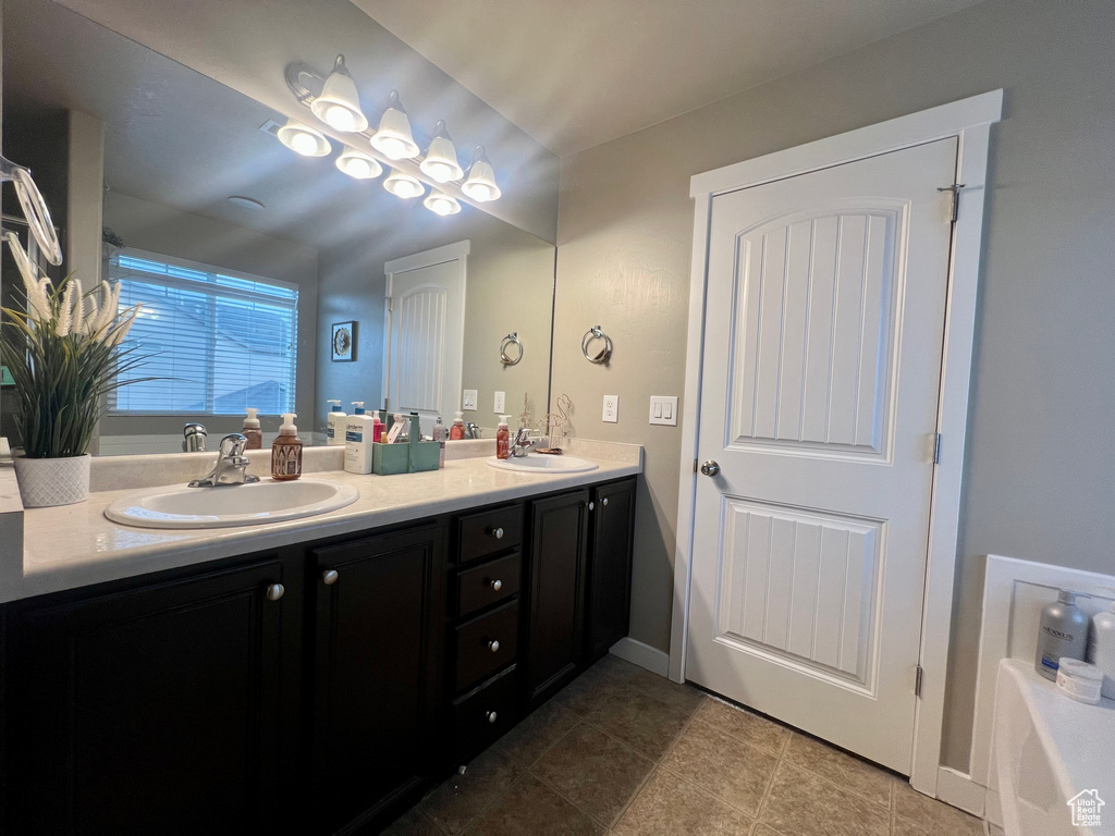 Bathroom with a bath, tile patterned flooring, double vanity, and a sink