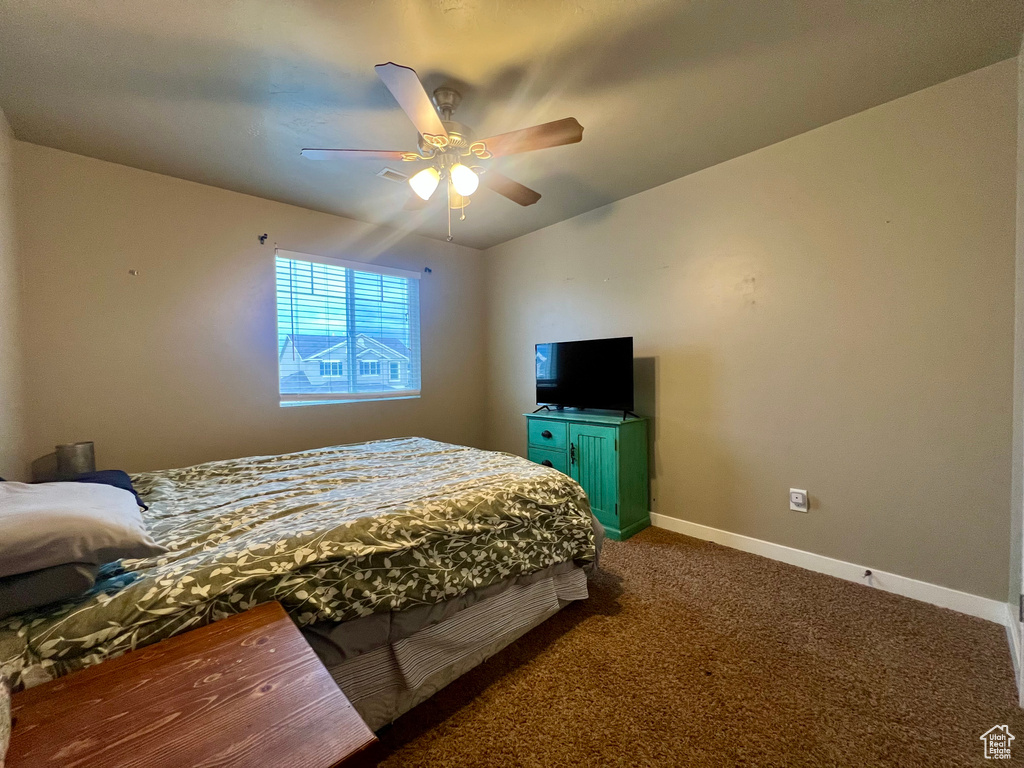 Carpeted bedroom with baseboards and a ceiling fan