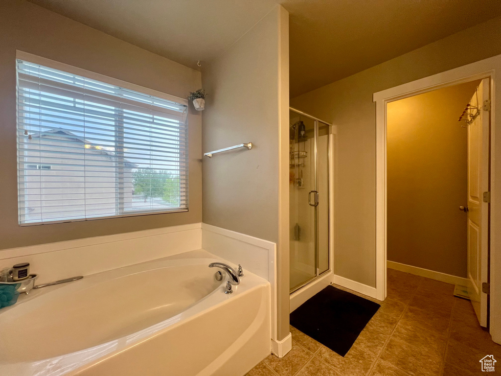 Bathroom featuring a stall shower, tile patterned flooring, and a bath