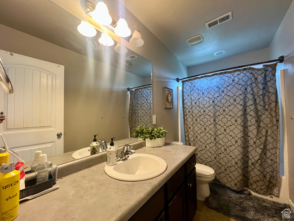 Full bath with toilet, visible vents, vanity, and a shower with shower curtain