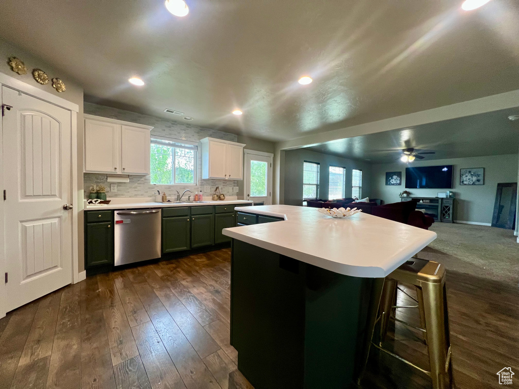 Kitchen featuring open floor plan, light countertops, a center island, and dishwasher