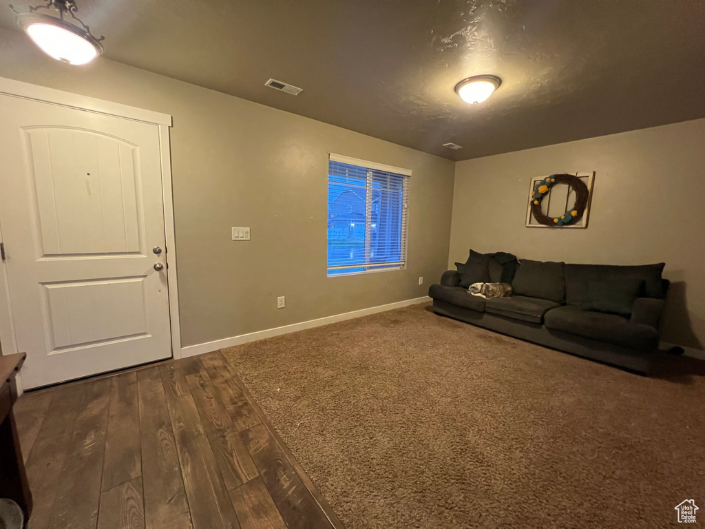 Living area with baseboards, visible vents, and dark wood finished floors