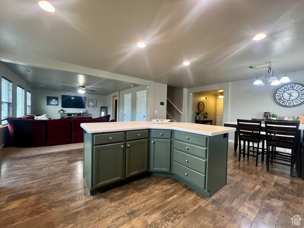 Kitchen with light countertops, dark wood finished floors, a kitchen island, and green cabinets
